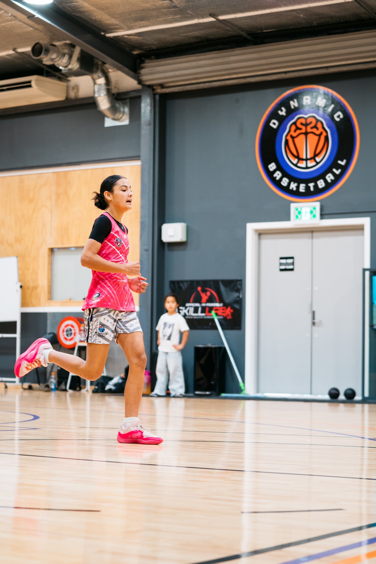 Athlete running on indoor basketball court during performance training session, JP ATHLETIC